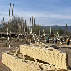 Two stacks of trusses sitting on a construction site